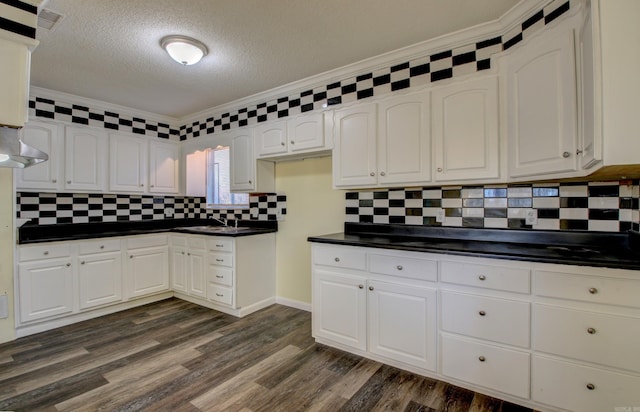 9425 S 365th Hwy, Little Rock, AR 72206 - kitchen featuring dark countertops, white cabinetry, a textured ceiling, backsplash, and dark wood-style floors