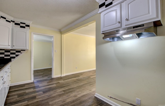 9425 S 365th Hwy, Little Rock, AR 72206 - kitchen featuring under cabinet range hood, dark wood-style floors, white cabinetry, and ornamental molding