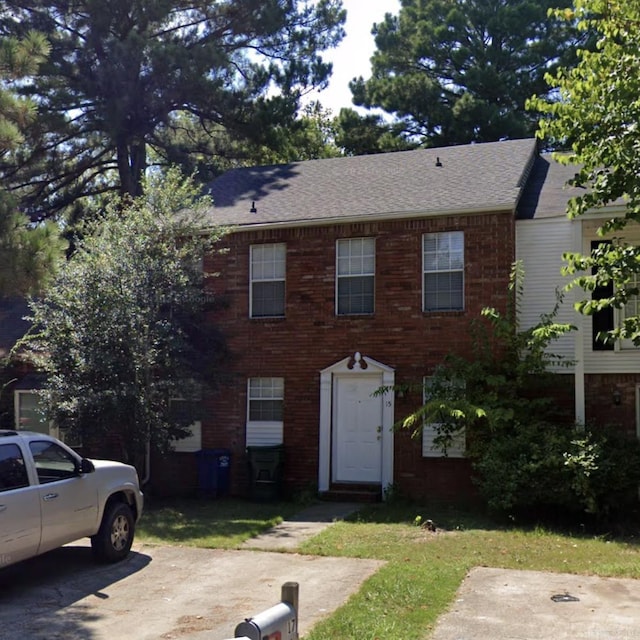view of front of home with brick siding and a shingled roof