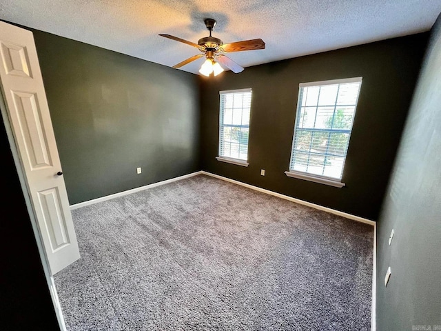 carpeted empty room featuring ceiling fan and a textured ceiling
