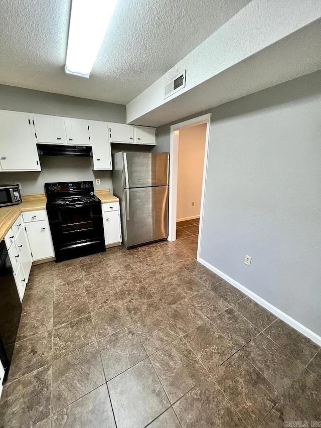 kitchen with freestanding refrigerator, electric range, ventilation hood, light countertops, and a textured ceiling