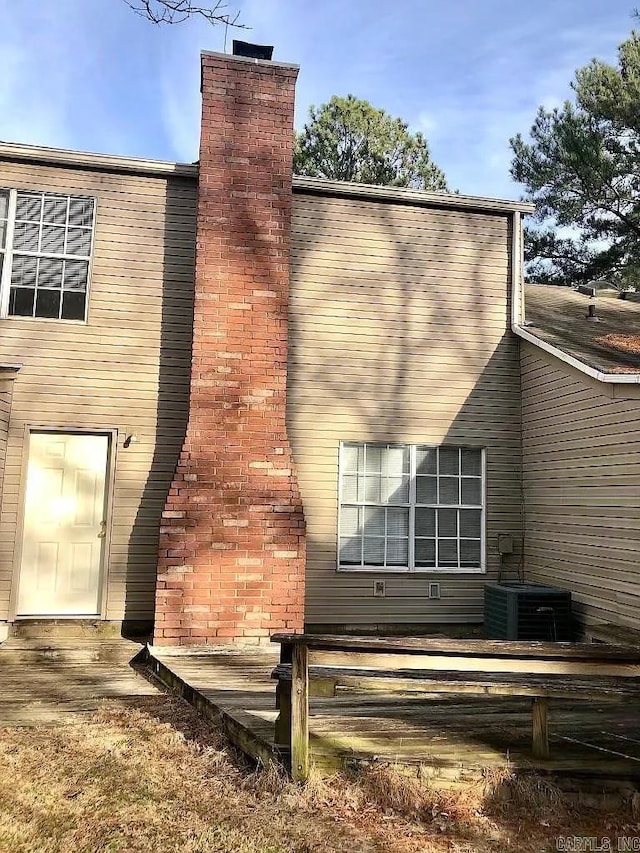 view of home's exterior with a chimney and a central air condition unit