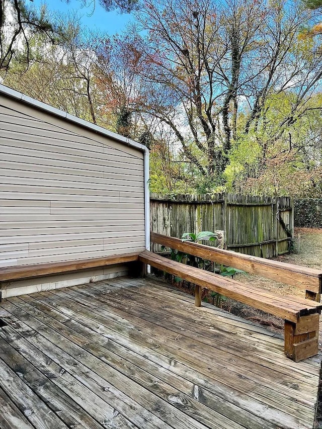 wooden deck with a fenced backyard