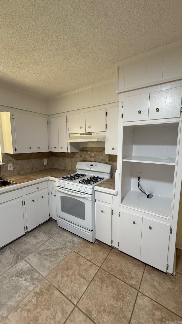 3003 Vancouver Dr, Little Rock, AR 72204 - kitchen featuring white gas stove, a textured ceiling, white cabinets, under cabinet range hood, and light countertops