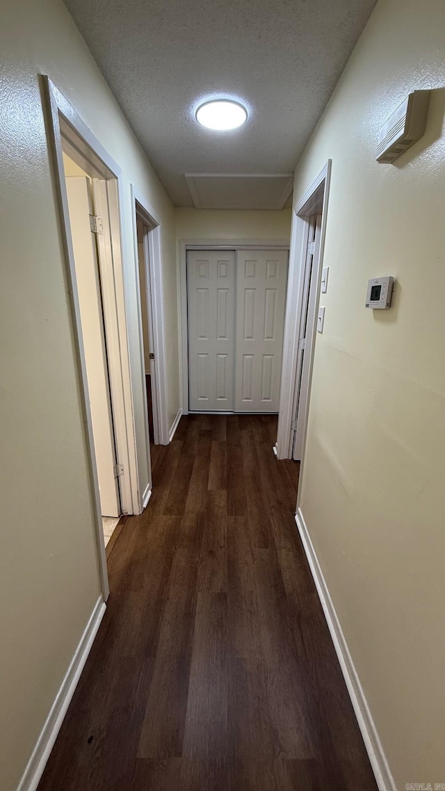 3003 Vancouver Dr, Little Rock, AR 72204 - hall featuring dark wood-type flooring, a textured ceiling, and attic access