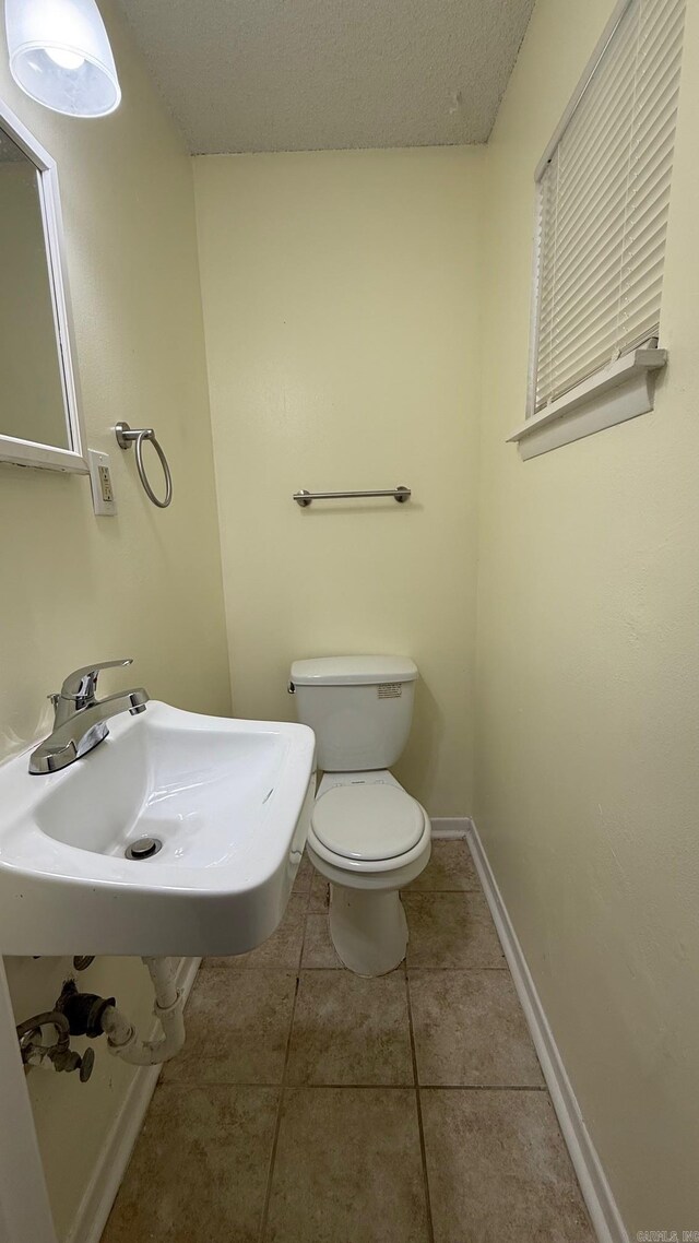 3003 Vancouver Dr, Little Rock, AR 72204 - half bathroom with a sink and tile patterned flooring