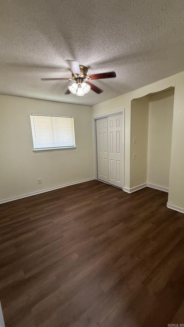 3003 Vancouver Dr, Little Rock, AR 72204 - unfurnished bedroom with dark wood-style flooring, a textured ceiling, a ceiling fan, and a closet