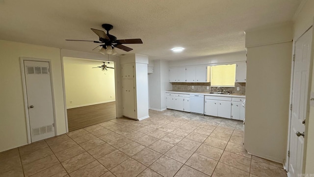 3003 Vancouver Dr, Little Rock, AR 72204 - kitchen with dishwasher, light countertops, light tile patterned floors, white cabinets, and ceiling fan