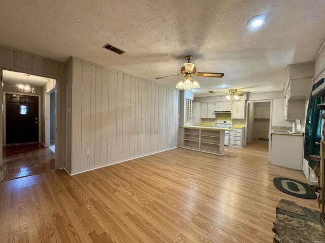 701 Emerald Gardens Dr, North Little Rock, AR 72118 - unfurnished living room with light wood-style floors, wood walls, ceiling fan, and a textured ceiling