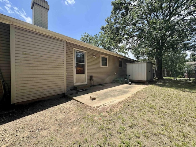 701 Emerald Gardens Dr, North Little Rock, AR 72118 - back of house with a storage shed, a patio area, a chimney, and a yard