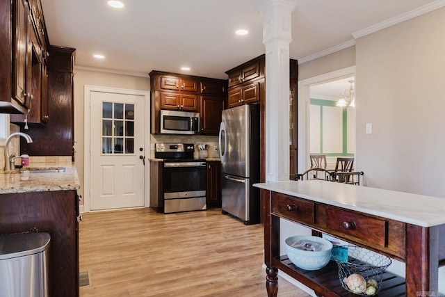15 Rocky Crest Ct, Little Rock, AR 72211 - kitchen featuring appliances with stainless steel finishes, light wood-style floors, backsplash, decorative columns, and crown molding
