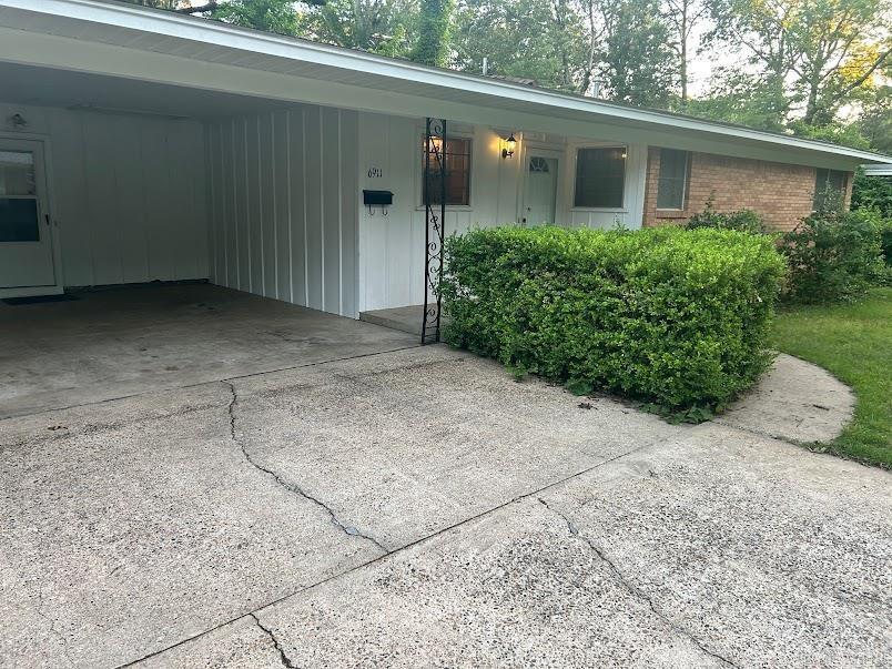 view of front facade with a carport, brick siding, and concrete driveway