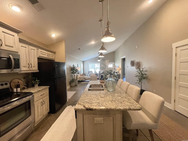 101 Cottage Loop, Heber Springs, AR 72543 - kitchen featuring appliances with stainless steel finishes, lofted ceiling, a breakfast bar area, a kitchen island with sink, and open floor plan