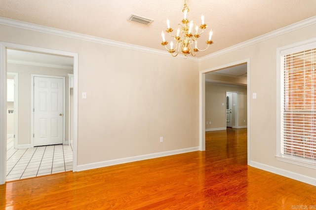 1940 Payne Ln, Conway, AR 72034 - spare room with a chandelier, wood finished floors, ornamental molding, a textured ceiling, and plenty of natural light
