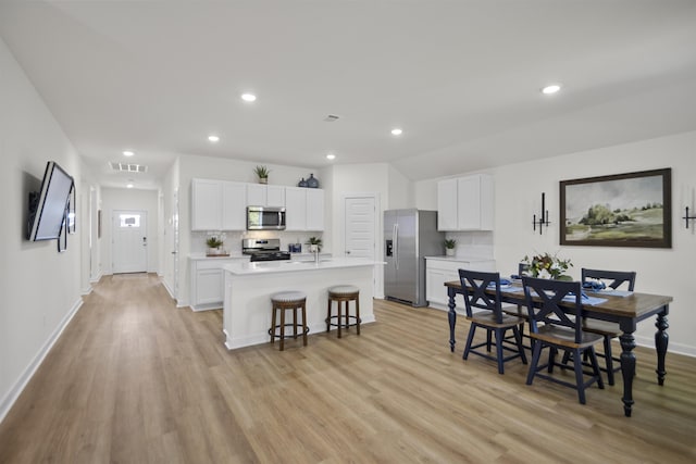 6804 Cypress Trl, North Little Rock, AR 72113 - kitchen with stainless steel appliances, light wood-style flooring, a kitchen breakfast bar, light countertops, and recessed lighting