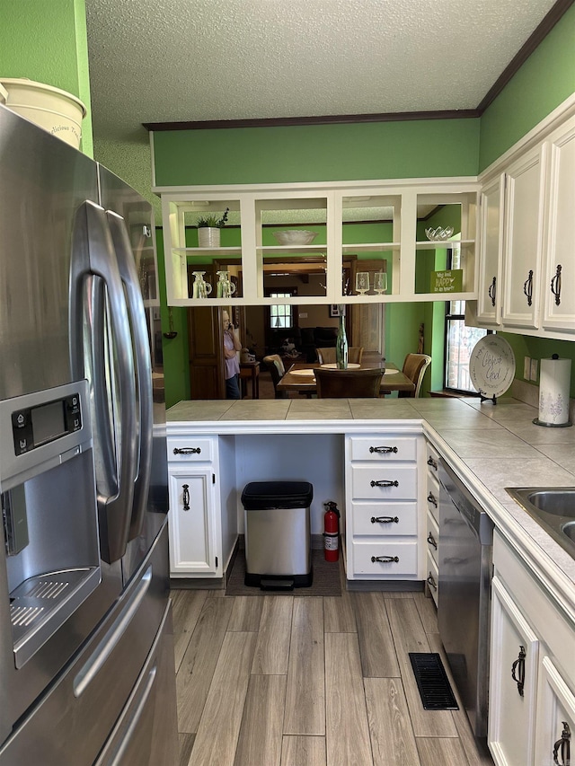 14400 Pikewood Dr, Alexander, AR 72002 - kitchen featuring stainless steel fridge with ice dispenser, dishwashing machine, white cabinetry, a textured ceiling, and a peninsula