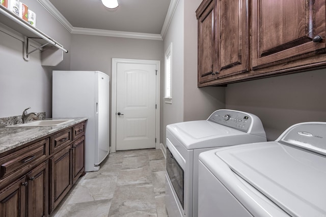 washroom with washer and dryer, ornamental molding, and cabinet space