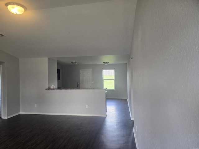 unfurnished living room with dark wood-style flooring