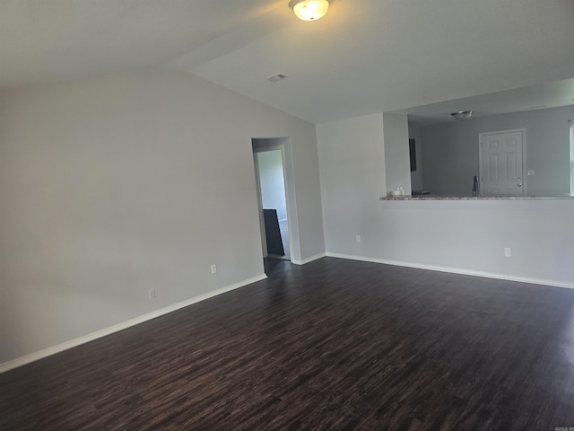unfurnished living room with dark wood-type flooring and lofted ceiling