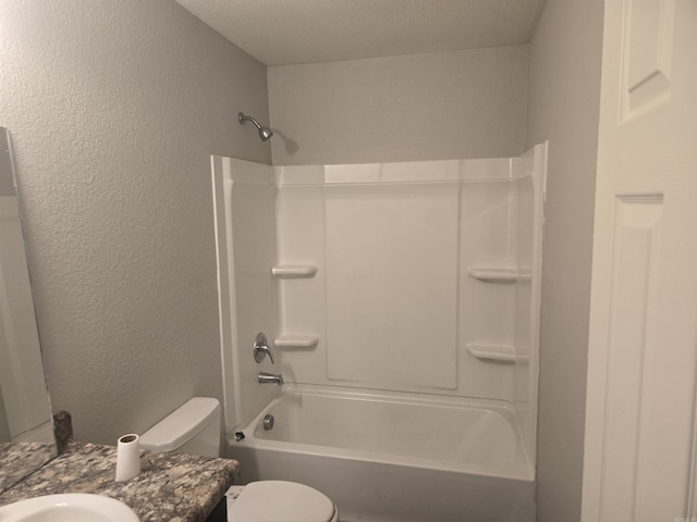 bathroom with vanity, shower / washtub combination, and a textured wall