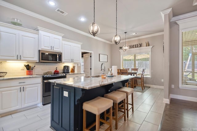 274 Reuben Dr, Alexander, AR 72202 - kitchen with stainless steel appliances, a center island with sink, decorative backsplash, plenty of natural light, and crown molding