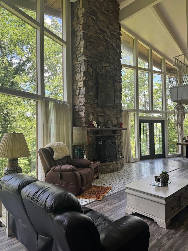 living room with wood finished floors, a fireplace, french doors, and a towering ceiling