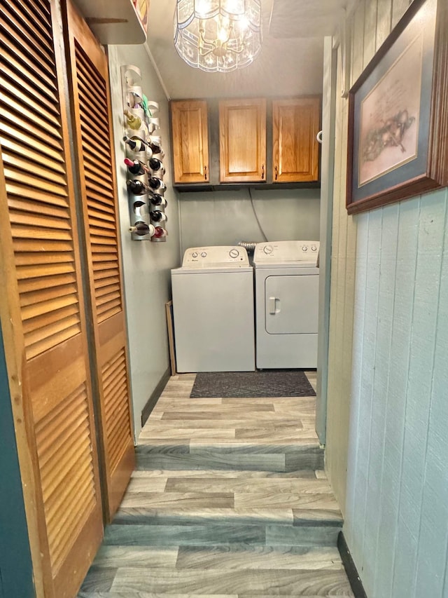 laundry room with independent washer and dryer, cabinet space, a chandelier, and light wood-style flooring