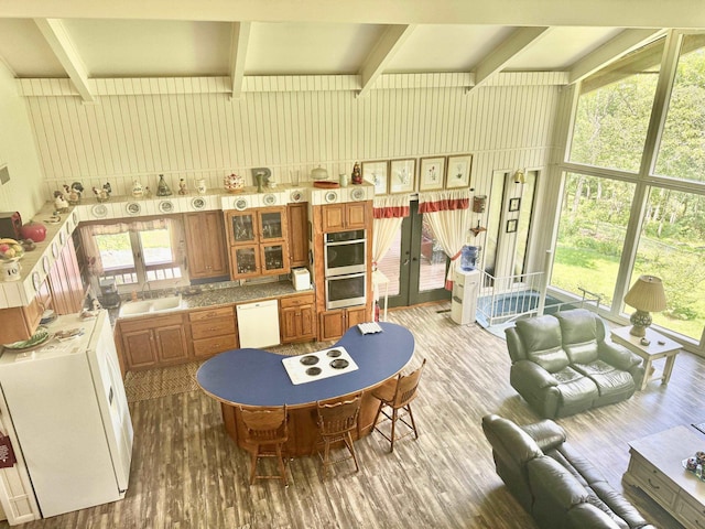 kitchen with dishwasher, french doors, brown cabinetry, wood finished floors, and stainless steel double oven