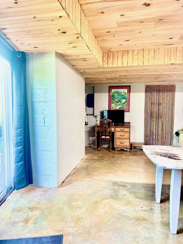 office space with wooden ceiling, concrete floors, and concrete block wall