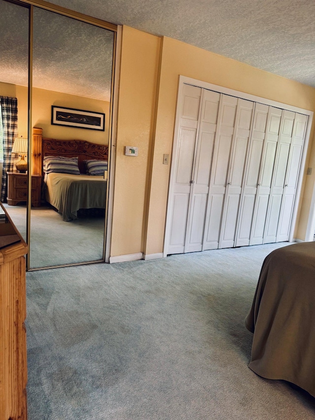 bedroom featuring a textured ceiling, carpet, and a closet