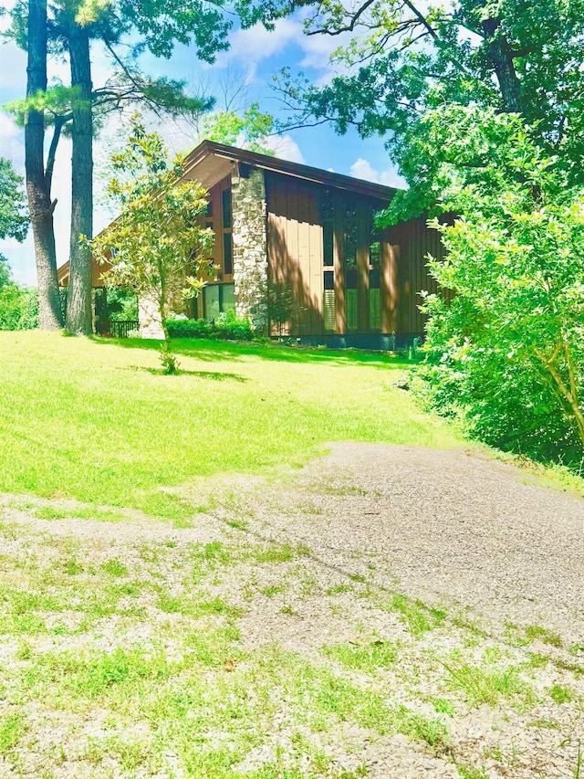 view of front facade with stone siding and a front yard