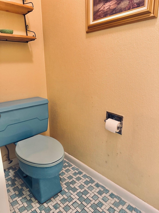 bathroom featuring toilet and baseboards