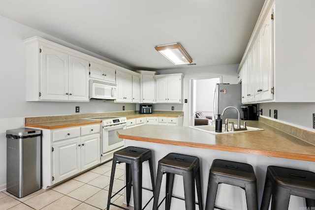 7328 W Ridge Cir, Sherwood, AR 72120 - kitchen featuring white appliances, a peninsula, a kitchen bar, and white cabinetry