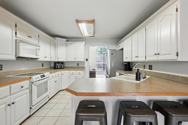 7328 W Ridge Cir, Sherwood, AR 72120 - kitchen with white appliances, a breakfast bar, a peninsula, white cabinetry, and light tile patterned floors