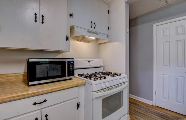 111 Greenland Cv, Little Rock, AR 72204 - kitchen featuring white gas range oven, under cabinet range hood, stainless steel microwave, light countertops, and wood finished floors