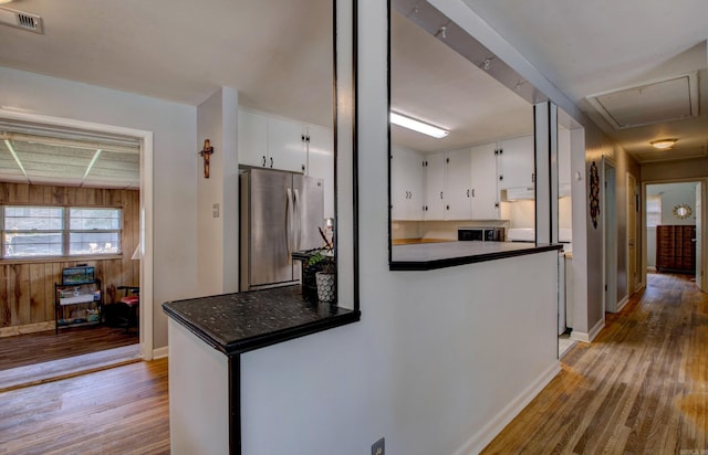 111 Greenland Cv, Little Rock, AR 72204 - kitchen featuring freestanding refrigerator, dark countertops, wood finished floors, white cabinetry, and wood walls