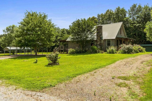 1105 Long Branch Rd, Heber Springs, AR 72543 - view of home's exterior featuring a lawn, driveway, a chimney, and a metal roof