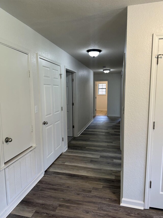 3505 Stockton Dr, Benton, AR 72015 - corridor featuring a textured wall, dark wood-style flooring, and a textured ceiling