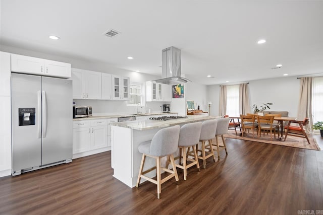 26 Buttermilk Rd, Little Rock, AR 72227 - kitchen with appliances with stainless steel finishes, a center island, glass insert cabinets, dark wood-style floors, and a kitchen breakfast bar