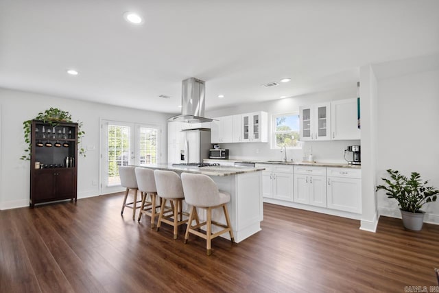 26 Buttermilk Rd, Little Rock, AR 72227 - kitchen with island range hood, a kitchen island, appliances with stainless steel finishes, dark wood finished floors, and healthy amount of natural light
