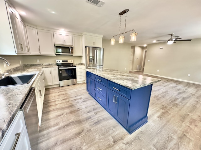 377 N 3rd St Unit B, Black Rock, AR 72415 - kitchen with stainless steel appliances, light wood-type flooring, blue cabinets, and a center island
