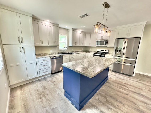 377 N 3rd St Unit B, Black Rock, AR 72415 - kitchen with appliances with stainless steel finishes, light wood finished floors, light stone countertops, a kitchen island, and recessed lighting