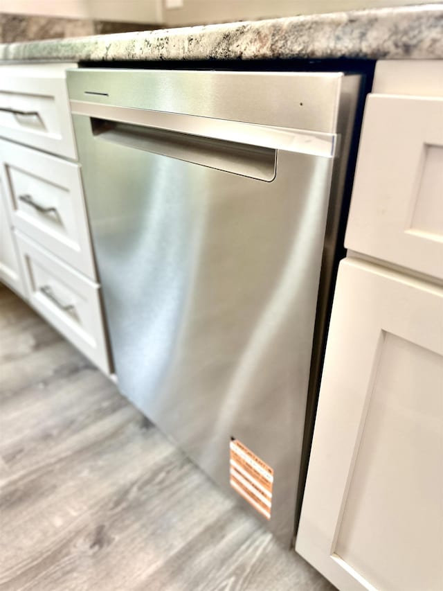 377 N 3rd St Unit B, Black Rock, AR 72415 - kitchen view of dishwasher, white cabinetry, and wood finished floors