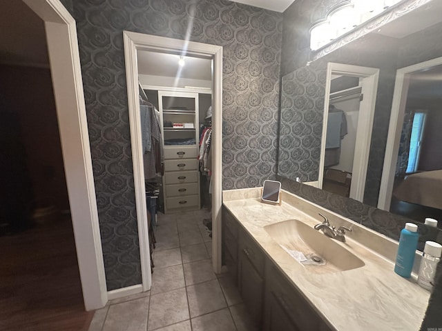 4 Jullian Cir, Dumas, AR 71639 - bathroom featuring vanity, wallpapered walls, a spacious closet, and tile patterned floors