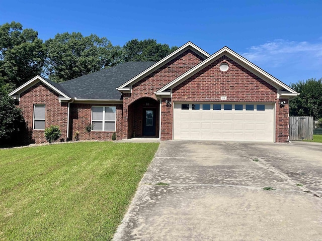 24 Tradewinds Dr, Cabot, AR 72023 - view of front of property with an attached garage, brick siding, driveway, a front lawn, and roof with shingles