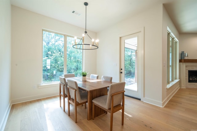 15112 Matterhorn Loop, Maumelle, AR 72113 - dining room featuring light wood-style floors, a chandelier, and a fireplace