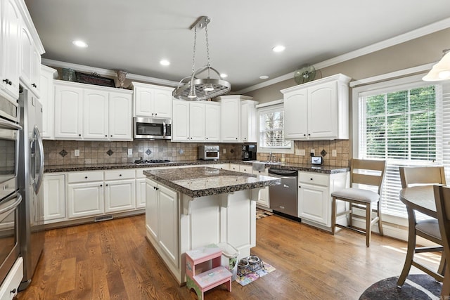 28 Chemin Ct, Little Rock, AR 72223 - kitchen with appliances with stainless steel finishes, crown molding, white cabinetry, backsplash, and decorative light fixtures