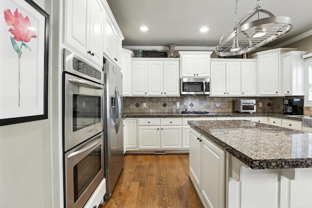 28 Chemin Ct, Little Rock, AR 72223 - kitchen with stainless steel appliances, dark wood-style floors, crown molding, dark countertops, and white cabinets