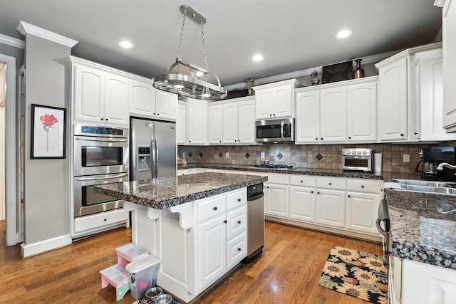 28 Chemin Ct, Little Rock, AR 72223 - kitchen featuring appliances with stainless steel finishes, crown molding, white cabinetry, backsplash, and recessed lighting