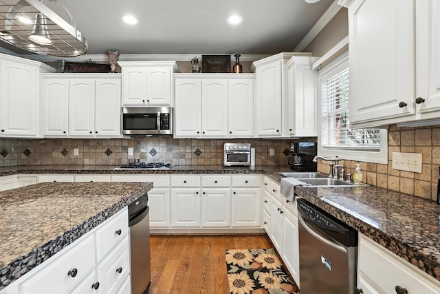 28 Chemin Ct, Little Rock, AR 72223 - kitchen featuring stainless steel appliances, white cabinetry, light wood finished floors, decorative backsplash, and recessed lighting